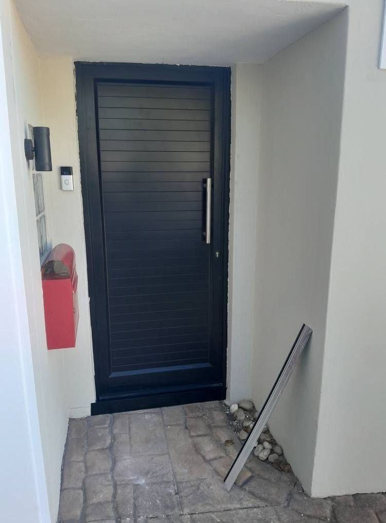 A charcoal aluminium front door with horizontal panels