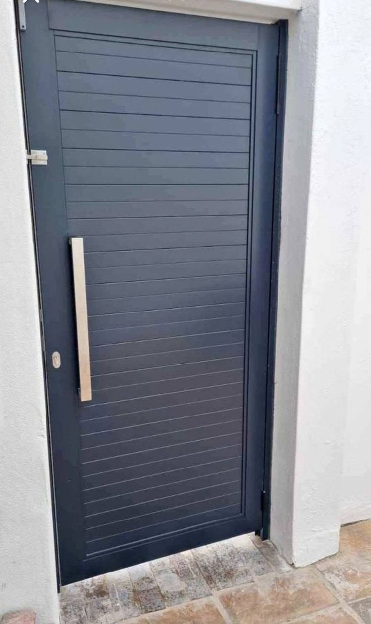 A charcoal aluminium front door with a long pull handle