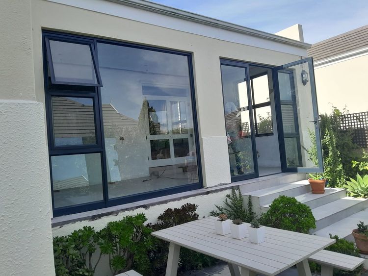 Charcoal aluminium windows on the front of a house with a garden
