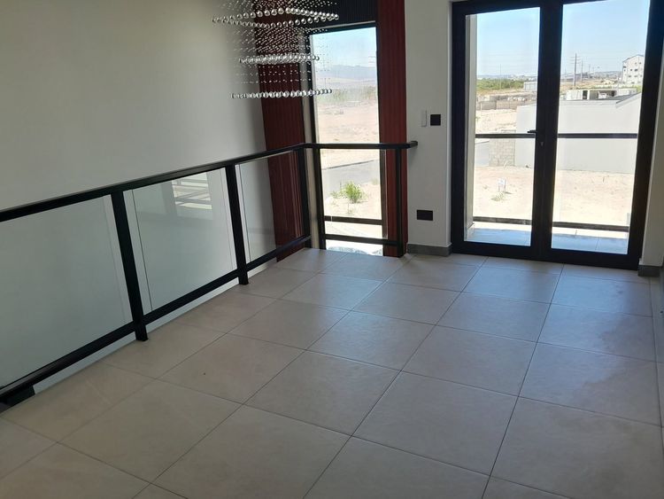 A glass balustrade with a black rail on a first-floor landing