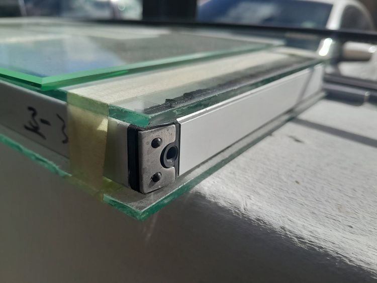 The edge of a glass pane set in an aluminium profile