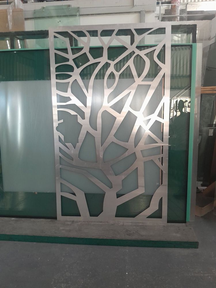 An aluminium screen with a laser-cut tree pattern
