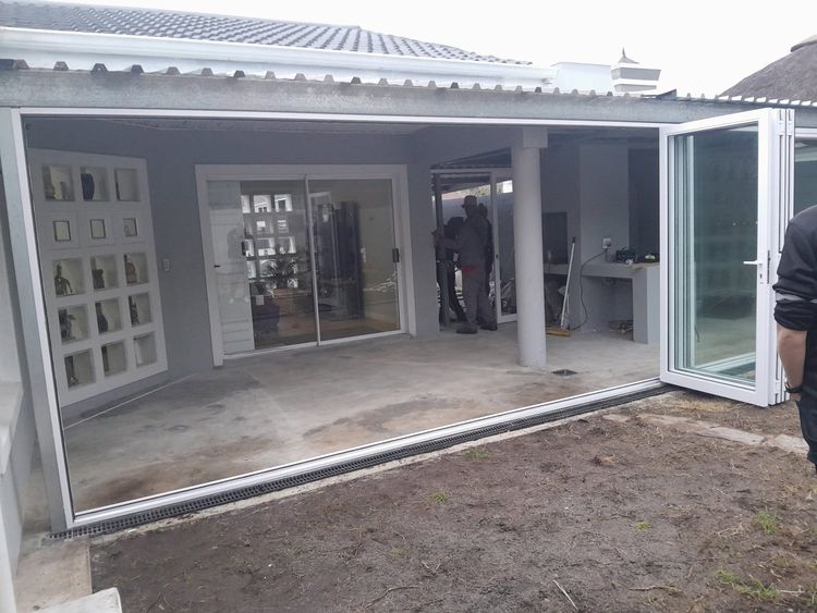White aluminium folding doors opened on a covered patio