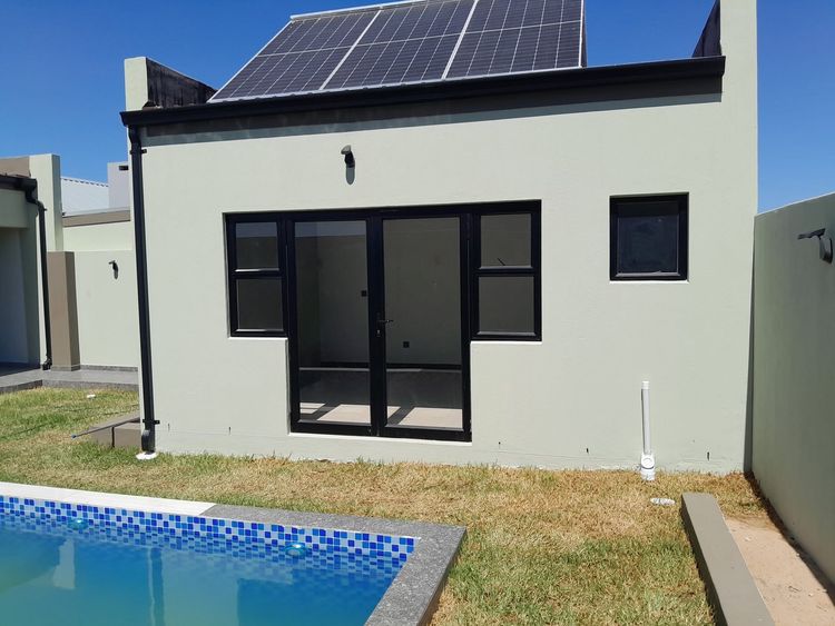 Black aluminium doors and windows on a pool house under solar panels