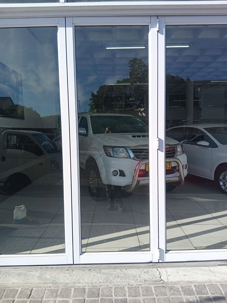A glass and white aluminium door on a car showroom