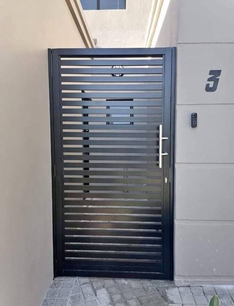 A charcoal slatted aluminium pedestrian gate with a long handle