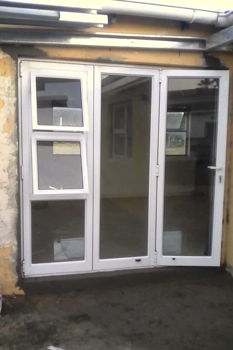 White aluminium folding doors with top-hung windows, fitted to a patio