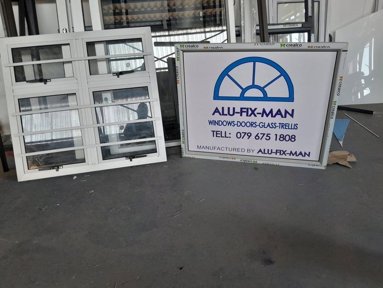 White aluminium windows finished in the workshop beside the Alu-Fix-Man signboard